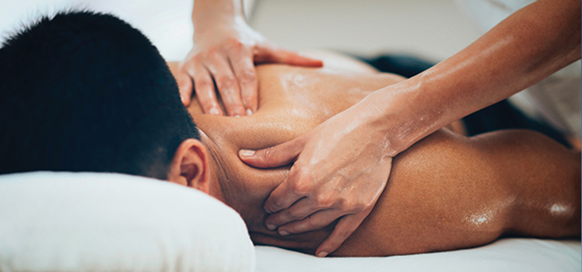 Massage therapist providing a soothing back massage to a man at Glamour Spa Center, Islamabad F10, promoting relaxation and well-being.